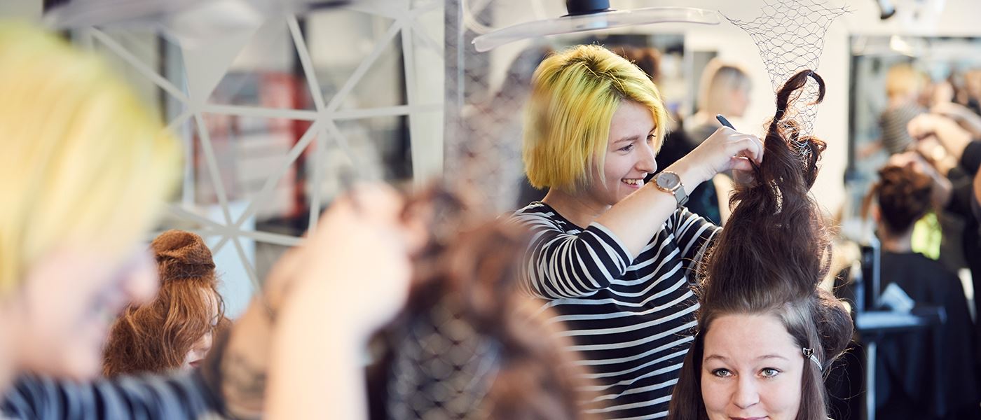 Studerende laver opsætning af hår på frisøruddannelse