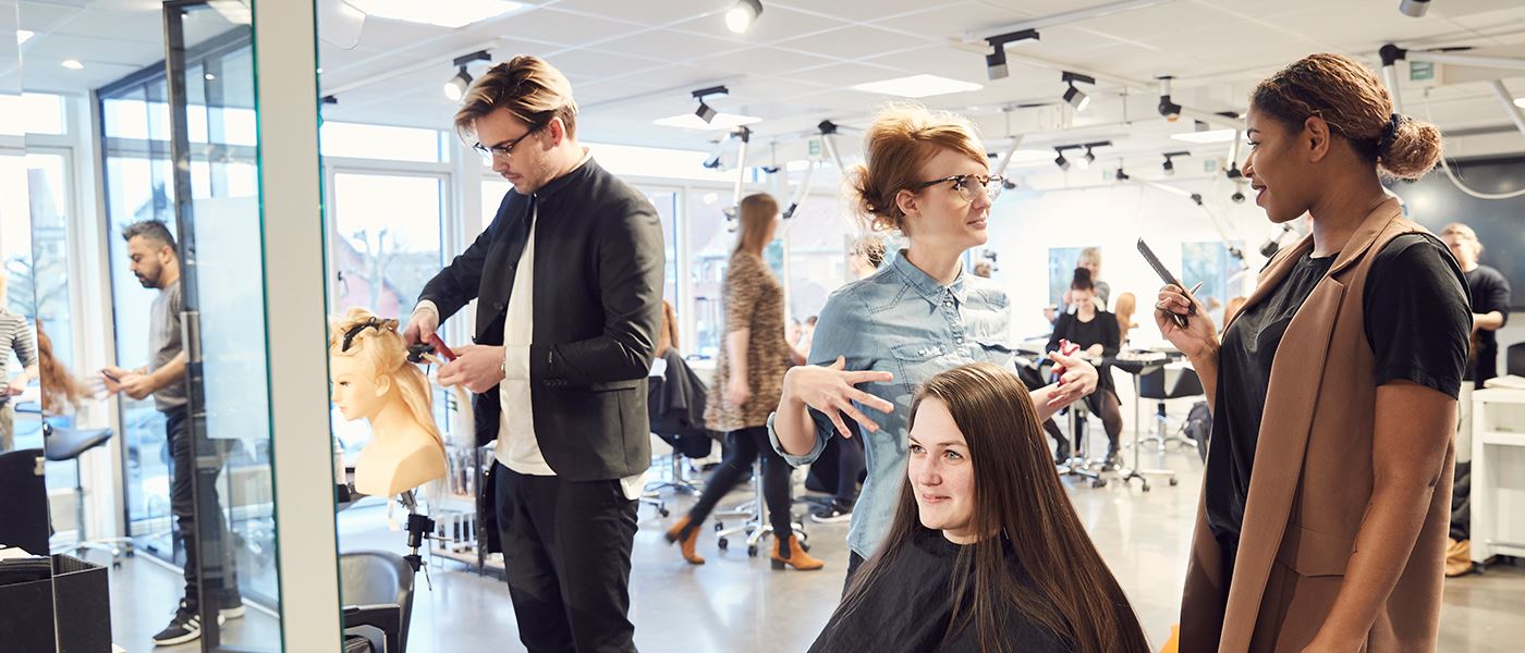 Frisørstuderende klipper på frisøruddannelse